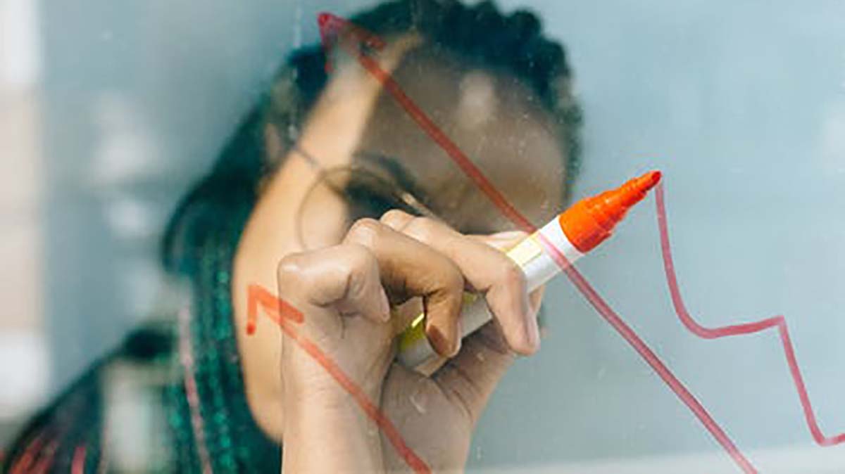 woman drawing chart on glass image of woman drawing chart on glass