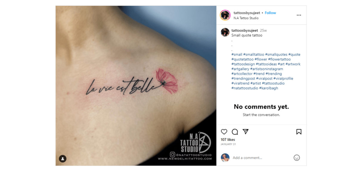 @tattoosbysujeet text tattoo From the Instagram page of @tattoosbysujeet is an example of a text-based tattoo. It reads “la vie est belle”. The end of the cursive “e” at the end turns into the stem of a flower with a red rose petal emerging from it.