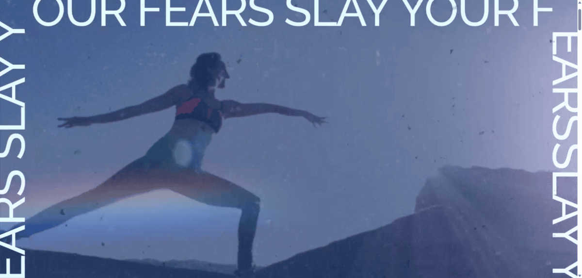 Brett Larkin website video On the homepage of the website for Brett Larkin, there’s a video reel in the hero section. In this screenshot, we see Brett in the Warrior II yoga pose. Around the blue-filtered image is text that reads: “Slay your fears” over and over.